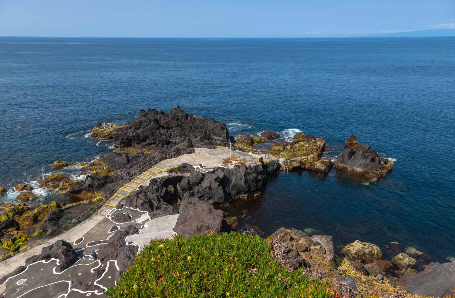 Piscina natural das Cinco Ribeiras na costa sudoeste da ilha Terceira, com rocha vulc&acirc;nica e mar aberto ao fundo