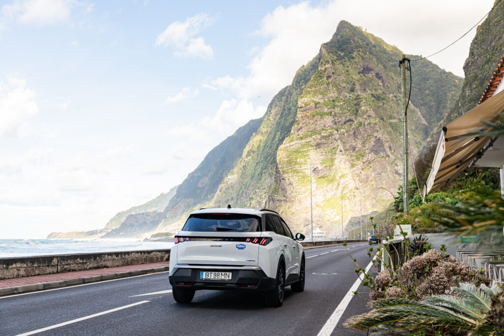 A vantagem de alugar carro sem cartão de crédito. Passeio pela margem num SUV, com paisagem da ilha da Madeira em foco, destacando as suas robustas montanhas.